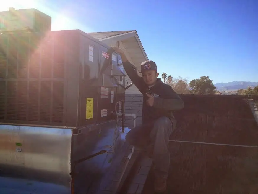 HVAC technician performing Air Duct Repair on a rooftop unit in Brookfield